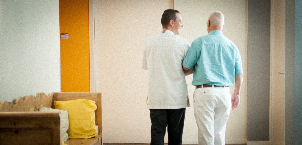 Zorgmedewerker begeleidt oudere man