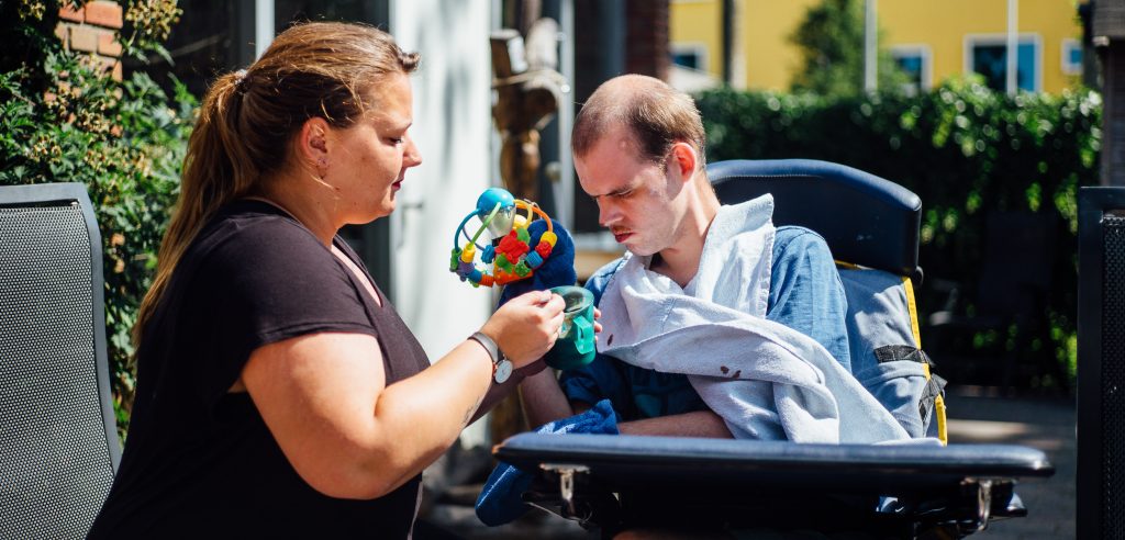 Gehandicapte man krijgt hulp bij het eten