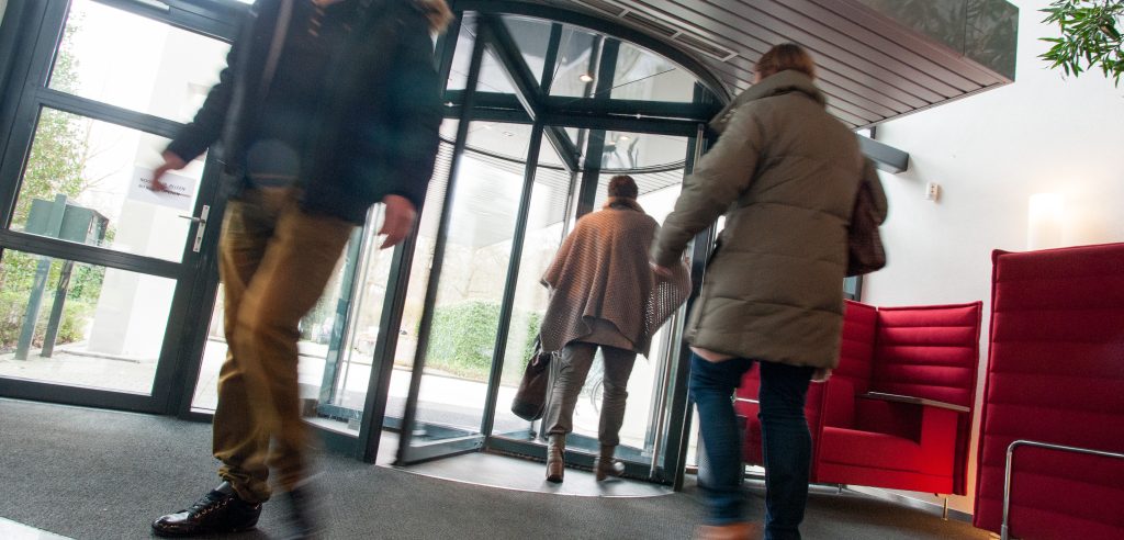 Mensen gaan een gebouw uit en komen binnen