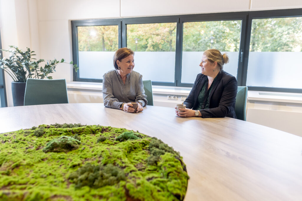 Collega's zitten aan tafel en zijn met elkaar in gesprek