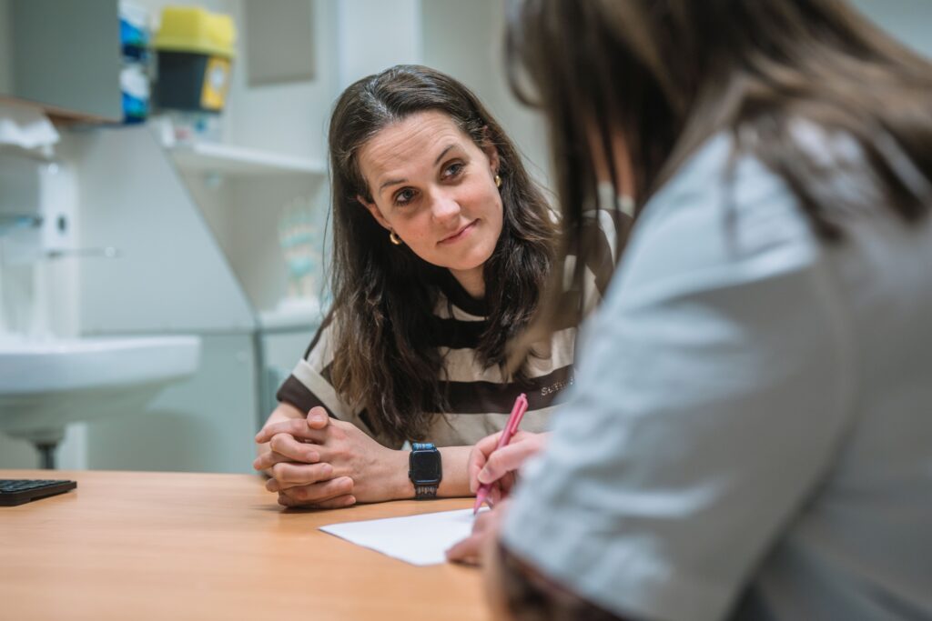Medisch specialist en patiënt zijn met elkaar in gesprek in de behandelkamer.
